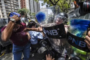Venezuela's opposition activists scuffle with riot police during a protest against Nicolas Maduro's government in Caracas on April 4, 2017.  Protesters clashed with police in Venezuela Tuesday as the opposition mobilized against moves to tighten President Nicolas Maduro's grip on power. Protesters hurled stones at riot police who fired tear gas as they blocked the demonstrators from advancing through central Caracas, where pro-government activists were also planning to march. / AFP PHOTO / JUAN BARRETO